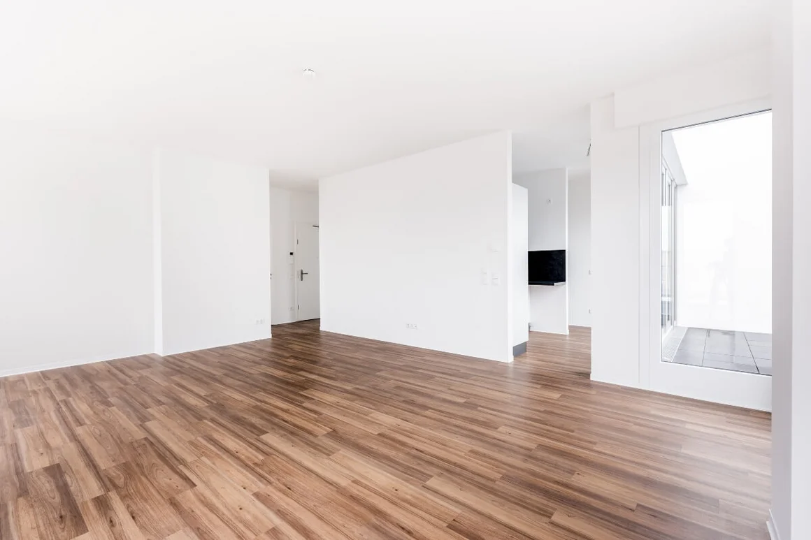 Leerer Wohnraum mit Parkettboden